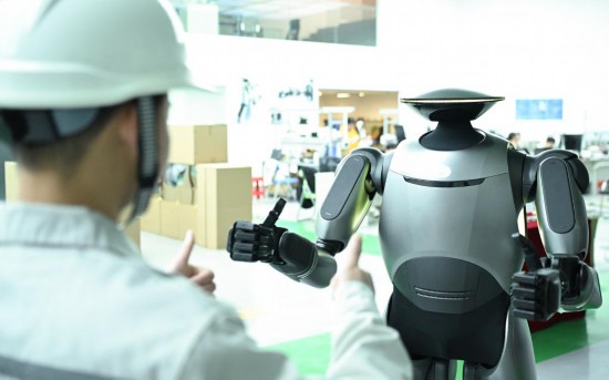 在广汽研究院，人形机器人团队的周仁义在演示GoMate机器人互动功能（新华社记者 邓华 摄）